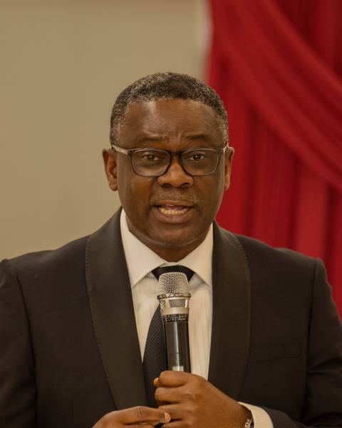 Pastor Akinloye Akintunji speaking with a microphone