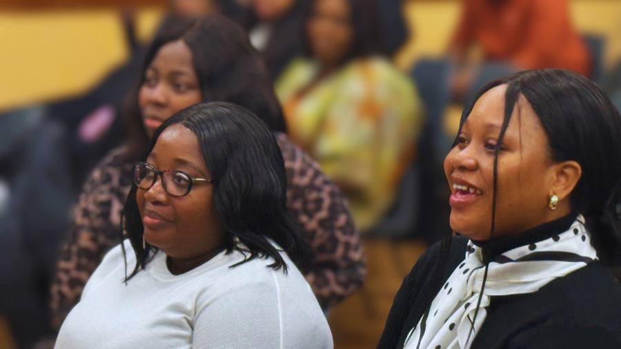 Two smiling members seated together in the congregation